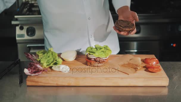 Capo cucina in vestaglia bianca rovescia ketchup sul panino e parte per un'altra bottiglia — Video Stock