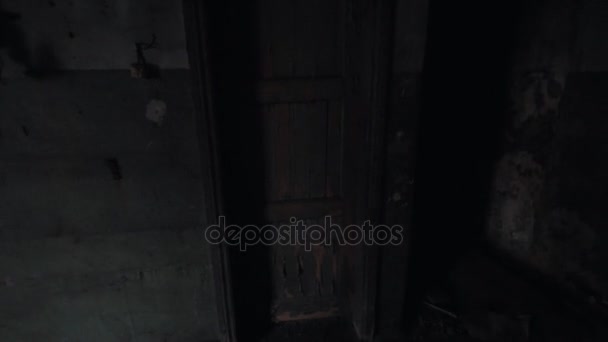 Synvinkel man sparkar dörren som leder in i mörkret i övergiven byggnad — Stockvideo