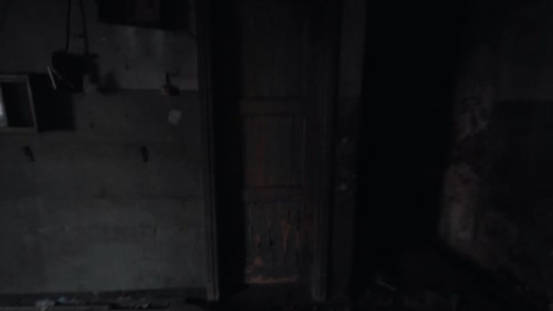 Point de vue pieds mâles coups de pied porte menant à l'obscurité dans le bâtiment abandonné — Video