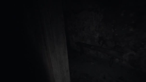 Человек с фонариком оглядывается по сторонам в темной пустой комнате — стоковое видео