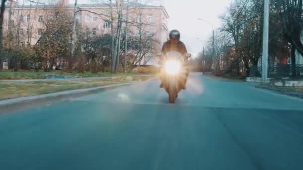 헬멧에 자전거 타고 시 기숙사 지역에 따라 카메라를 향해 오토바이 — 비디오
