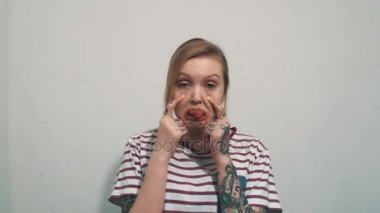 Çizgili gömlekli çekme göz kapakları Haritayı bölünmüş olsun kamera içine komik sarışın kız