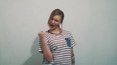 Dövmeler muzaffer poz ve çığlık ile çizgili gömlekli heyecanlı kız