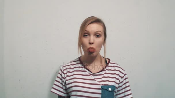 Funny blonde girl in striped shirt teasing, show split tounge into camera — Stock Video