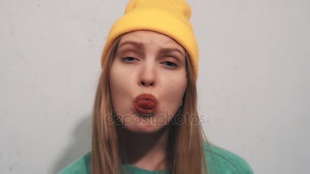 Chica bonita en sudadera verde sombrero gorro amarillo burlas, mostrar la lengua dividida — Vídeo de stock