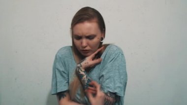 Pretty genç kız kulak eti tüneller ve buz gibi dövmeler ile gri gömlek