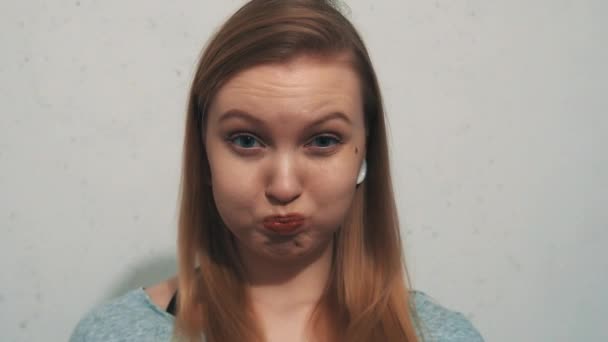 Αστεία νεαρή κοπέλα σε γκρι μπλούζα με αυτί σήραγγες κατέχει αναπνοή φυσά-επάνω τα μάγουλα — Αρχείο Βίντεο