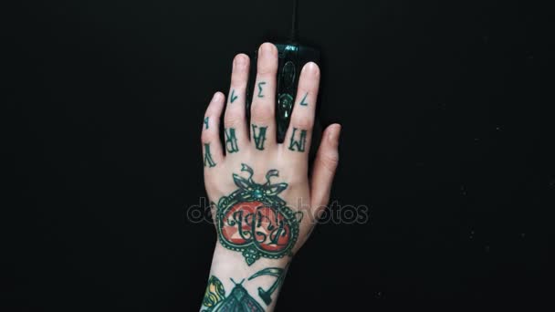 Tattooed female left hand energicaly using computer mouse on black table — Stock Video