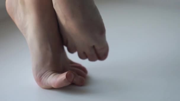 Женщина босые ноги стоя на пальцах ног на белом полу поворачивая на точку — стоковое видео