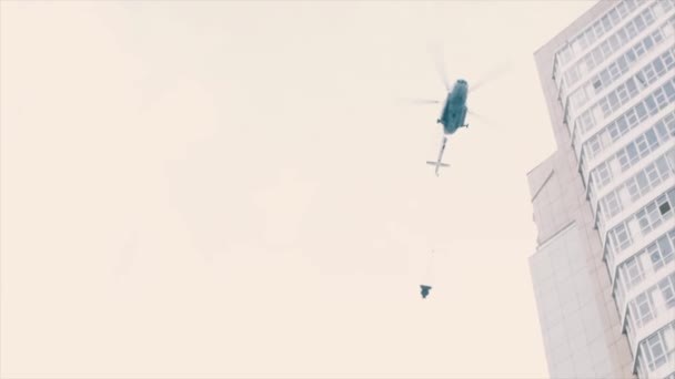 Helicóptero de bombeiro com cisterna de água em voos em cadeia sobre prédio de fumantes — Vídeo de Stock