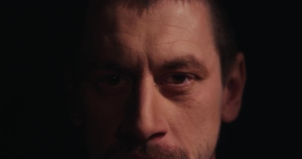 Kaukázusi borostás barna ráncos férfi portréja squints szemek — Stock videók