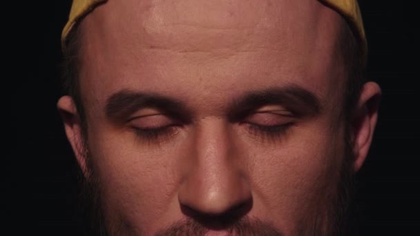 Portrait de jeune homme épuisé avec barbe en casquette jaune regarde dans la caméra — Video