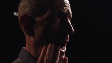 Gri saçlı buruşuk ihtiyar ekose gömlekli el ağzıyla kapsar