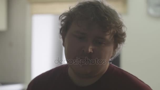 Жирне кучеряве волосся білий чоловік засмучується у світлій вітальні — стокове відео