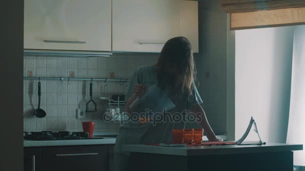 不器用な眠そうな若い女の子がスリップ赤いグラスにジュースを注ぐし、倒れる — ストック動画
