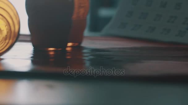 Orange glas faller av kanten av våta köksbordet i tidig morgon — Stockvideo
