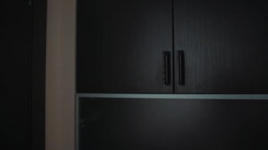 Tanınmayan genç kadın duvar dolabı açtığında, kutuları çok düşer