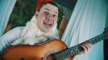 Sakallı cüce dans ediyor ve akustik gitar çalar gibi giyinmiş neşeli adam