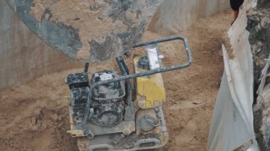 Slowmotion Ekskavatör laddle çekerek plaka Kompaktör aşağı kum hendekte üzerinde