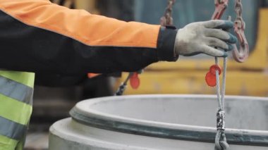 İşçi beton odası kuyu halka zincir üzerinde yukarı kaldırarak metal ilmik bekle