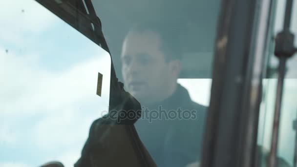 Kierowca koparki pracujących w przeszklone kabiny, slowmotion. Błękitne niebo — Wideo stockowe