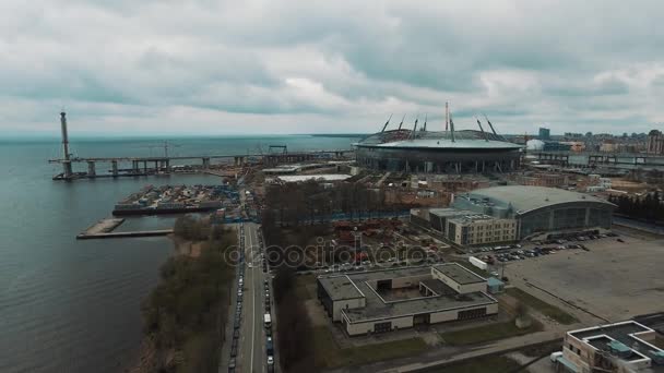 Аэросъемка современного стадиона на берегу залива в осенний облачный день — стоковое видео