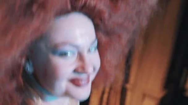 Woman in lush rufous hair wig grimacing and dancing on scene with troupe — Stock Video