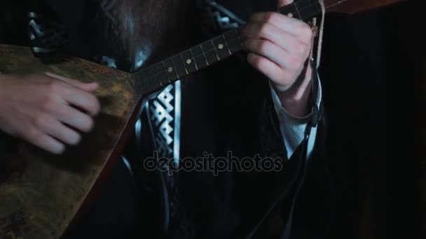 Männerhände schlagen langsam Saiten traditioneller russischer Balalaika mit Ornamenten — Stockvideo