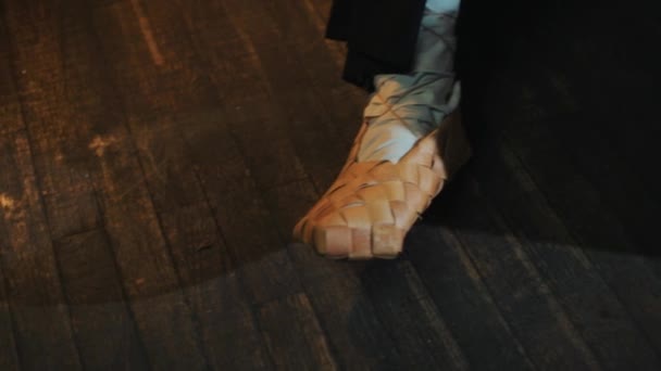Dwie pary nóg w tradycyjny rosyjski bast buty, mężczyzna oczyścić pot sadzy — Wideo stockowe