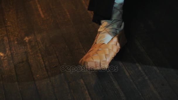 Deux paires de jambes dans des chaussures russes traditionnelles, homme nettoyer pot de suie 