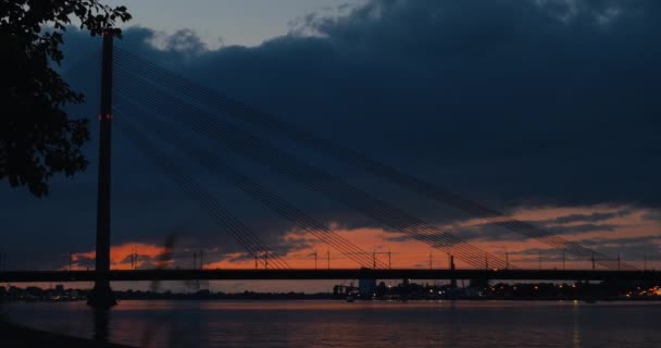 A noite de verão passa na cidade. Vista na enorme ponte fluvial. Pôr do sol. Prazo de validade . — Vídeo de Stock