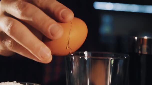 Bartender hand brakes egg and puts it into glass making cocktail — Stock Video