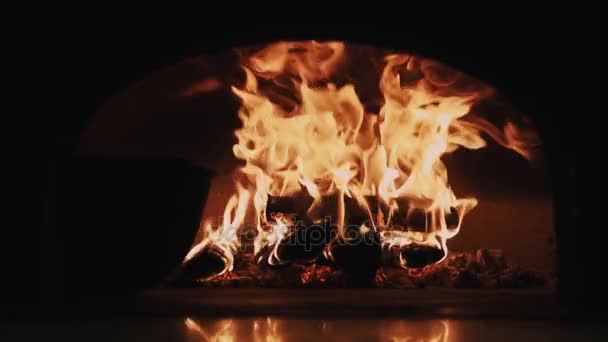 Llamas de fuego rojo cálido quema troncos en la chimenea habitación oscura — Vídeo de stock