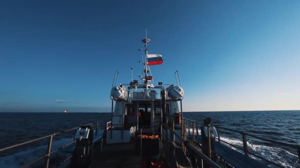 Моторний човен з прапор Росії швидко, переходячи морською водою під чисте небо — стокове відео