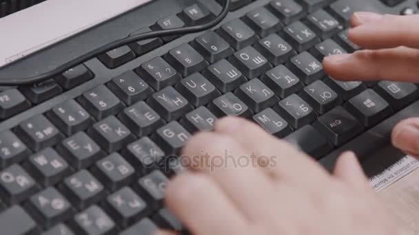 Hands of office worker pressing buttons on keyboard and holding pen — Stock Video