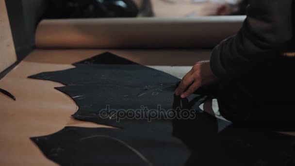 Woman fashion designer hands cutting edges on piece of clothing with scissors — Stock Video