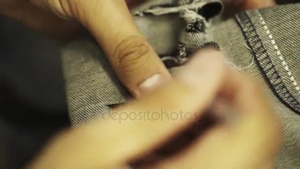 Man op maat handen maken scheuren en gaten in denim jeans met snijden naald — Stockvideo