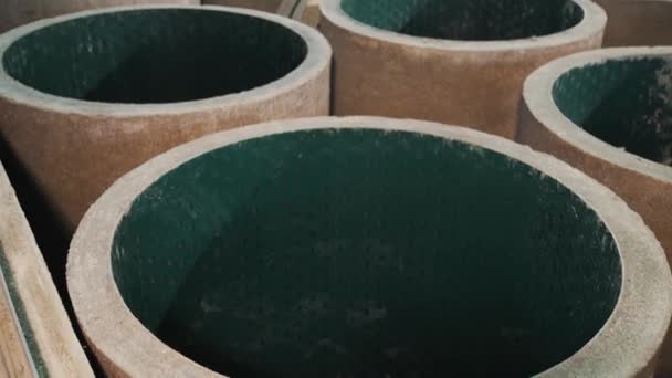 Новые бетонные канализационные кольца с зеленым пластиком внутри на складе завода — стоковое видео