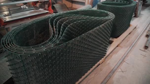 Rolls of green plastic sheets with bristles at factory with working benches — Stock Video