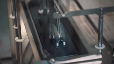 Metal otomatik makine kanca rode fabrikada, sıvı içinde lensler immerses