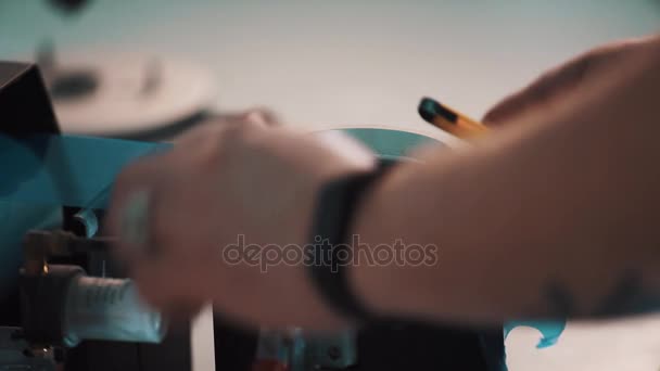 Lens manufacturer. Man hands put blue film on lens using plotting machine — Stock Video