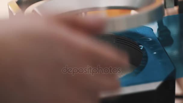 Las manos masculinas sellan la lente en película azul utilizando la máquina de trazado en la fabricación — Vídeos de Stock