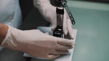 Laboratuvar işçinin lensler özel kutusunda tablo Danışma kağıda kağıt üzerine koyar