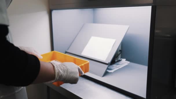Женщина-инженер поставила линзы оранжевой коробки на лист бумаги на планшет — стоковое видео