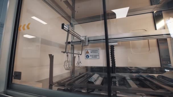 Automatische machine onderdompelen lenzen opknoping op metalen staaf op schudden frame — Stockvideo