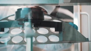 Gözlükçü laboratuarda üretilen lensler ile metal levha çıkar