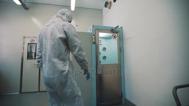 Scienziato in abiti sterili cammina in camera di disinfezione e scherzare — Video Stock