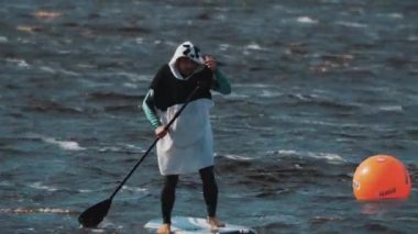 Dostum giyer panda takım bir sörf tahtası üzerinde beacon bir kürek ile kürek çevresinde rides
