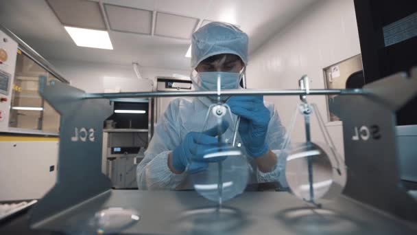 Engineer clputs magnifier lenses on special metal holder at laboratory — Stock Video