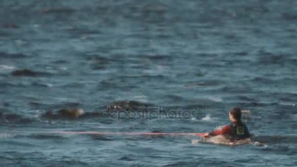 Wakeboarder em maiô cheio retirado da água com resistir com corda esticada — Vídeo de Stock